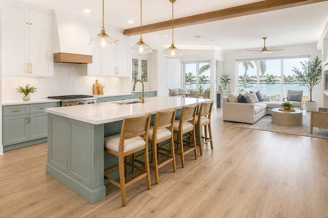 Open-plan remodeled kitchen and living space with a seafoam island and water view